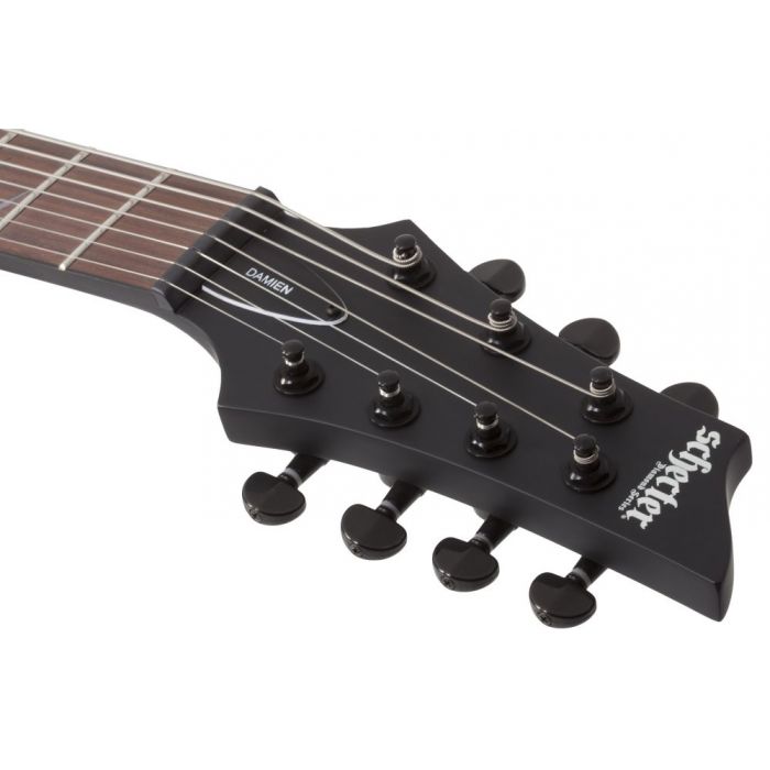 Closeup of the headstock on a Schecter Damien-7 7-String Electric Guitar, Satin Black