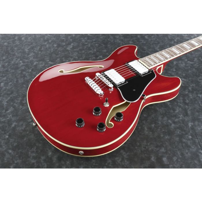 Closeup frontal view of a trans cherry red semi hollow Ibanez AS73 guitar