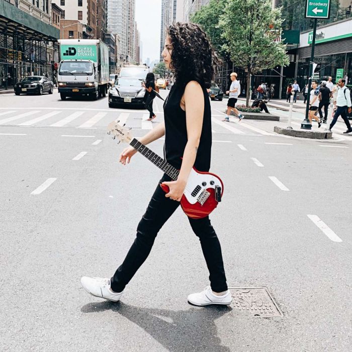 Woman Crossing Street and Looking Cool While Carrying a Vox SDC-1 Mini Electric Guitar