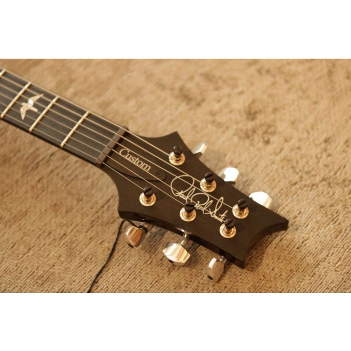 Closeup shot of the headstock on a PRS Ltd Edition Custom 24 Black Gold Ebony Electric Guitar