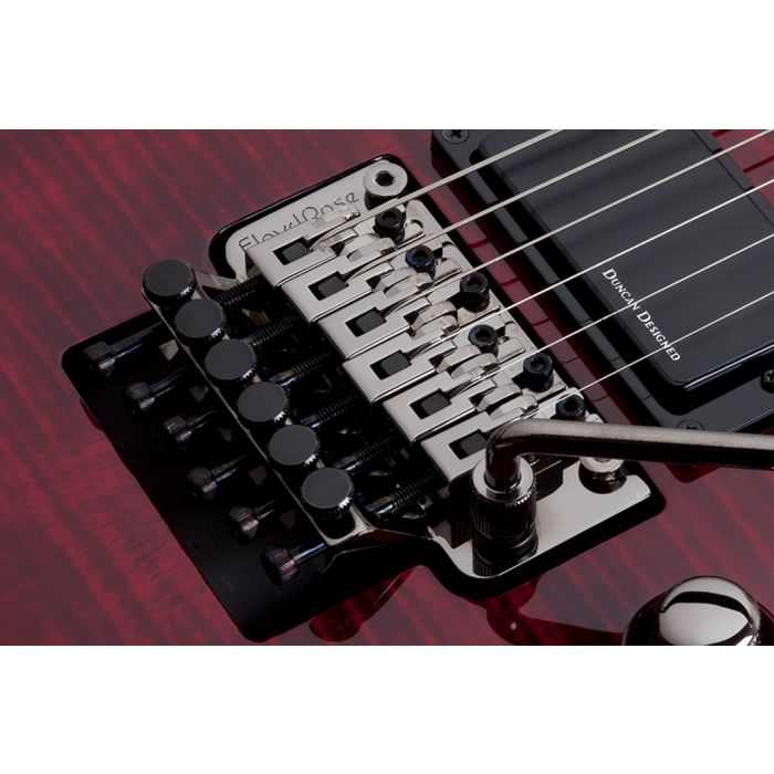 Detailed view of the tremolo bridge on a Schecter Demon-6 FR Electric Guitar, Crimson Red